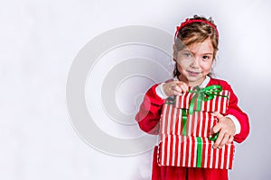 Happy little smiling girl with christmas gift boxes