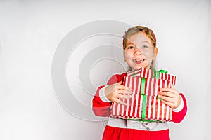 Happy little smiling girl with christmas gift boxes