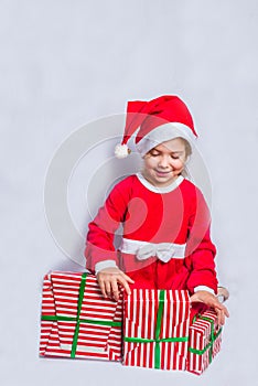 Happy little smiling girl with christmas gift boxes