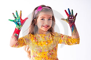 Happy little student girl showing painted hands - childhood and drawing concept, education and art