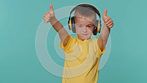 Happy little toddler children boy listening music via headphones, dancing disco, fooling, having fun