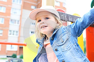 Happy little toddler girl plays outdoor in summertime