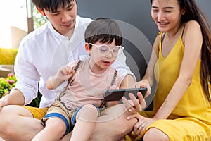 Happy Little young child using smart phone for playing and watching game or cartoon on internet online with family Lovely children