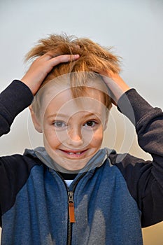 Surprised boy pulling hair with hands