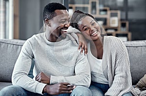 Happy, in love, and carefree couple relaxing, smiling and laughing together at home portrait while enjoying their