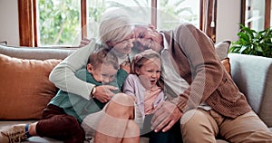Happy, love and children hugging grandparents on a sofa in the living room at modern home. Smile, bonding and young kids