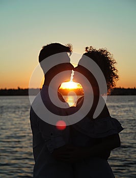 Happy couple dancing tango at sunset on the beach