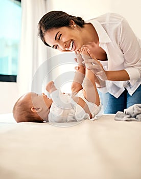 Happy, love and a mama with her baby in the bedroom of their home together for playful bonding. Family, children and a