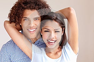 Happy and in love. Studio portrait of a happy young ethnic couple embracing and smiling at the camera.