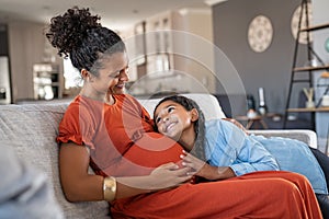 Happy lovely daughter hugging pregnant mother