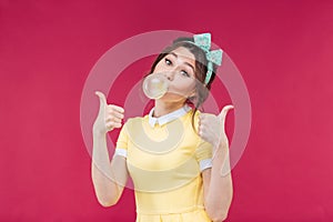 Happy lovely young woman with pink bubble of chewing gum