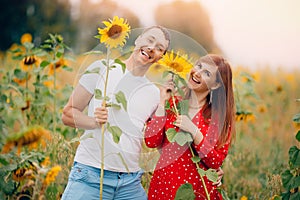 Happy lover couple man and woman in field sunflowers in red dress, sunlight