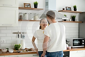 Happy lovers looking in eyes enjoying intimacy cooking breakfast photo