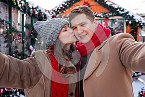 Happy lovers taking selfie while spending winter day at backyard