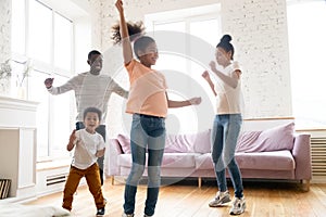 Happy loving african american family dancing to favorite song.