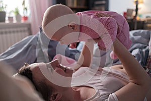 Happy loving caucasian mother spending time, playing with baby girl.