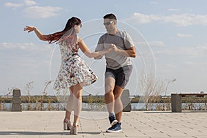 Happy loving couple embracing and kissing outdoors at summertime under blue sky. Love story. Couple in love. Sea background.