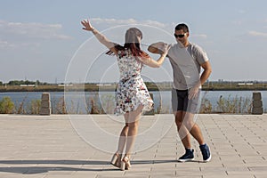 Happy loving couple embracing and kissing outdoors at summertime under blue sky. Love story. Couple in love. Sea background.