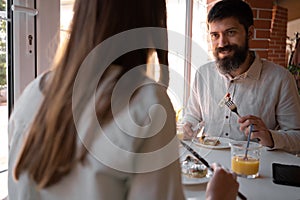 Happy loving couple enjoying breakfast in a cafe. Love, dating, food, lifestyle
