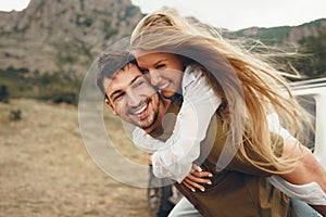 Happy loving couple hiking and hugging in mountains