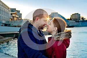 Happy loving couple hugging in city. Portrait of young attractive smiling man and woman relaxing on the pier by the sea