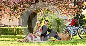 Happy loving couple relaxing in park with food. Enjoying their perfect date. Couple in love picnic date. Spring weekend