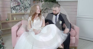 Happy loving couple sits on the sofa in the studio for a photo shoot.