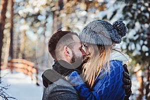 Happy loving couple walking in snowy winter forest, spending christmas vacation together.