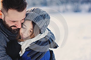 Happy loving couple walking in snowy winter forest, spending christmas vacation together. Outdoor seasonal activities.