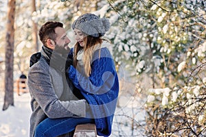 Happy loving couple walking in snowy winter forest, spending christmas vacation together. Outdoor seasonal activities.