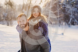 Happy loving couple walking in snowy winter forest, spending christmas vacation together. Outdoor seasonal activities.