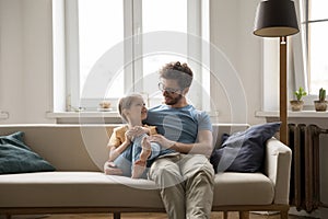 Happy loving dad hugging cute little daughter girl with tenderness