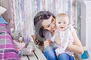 Happy loving family. Cute little girl is combing her mother`s hair