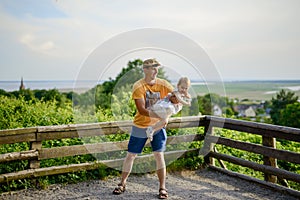 Happy loving family. Father and his daughter child girl playing and hugging outdoors. Cute little girl hugs daddy. Concept of