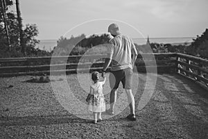 Happy loving family. Father and his daughter child girl playing and hugging outdoors. Cute little girl hugs daddy. Concept of