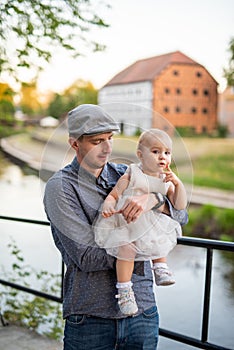 Happy loving family. Father and his daughter child girl playing and hugging outdoors. Cute little girl hugs daddy. Concept of