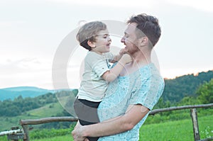 Happy loving family. Father and his son baby boy playing and hugging outdoors.