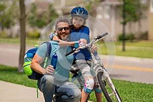 Happy loving family. Father and son hugging. Happy playful dad with excited kid son riding a bicycle on weekend. Sporty