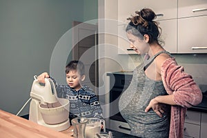 Happy loving family in the kitchen before Christmas. Mother and child preparing the dough, bake ginger cookies