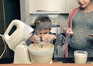 Happy loving family in the kitchen before Christmas. Mother and child preparing the dough, bake ginger cookies