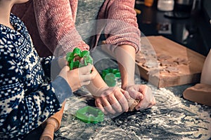 Happy loving family in the kitchen before Christmas. Mother and child preparing the dough, bake ginger cookies