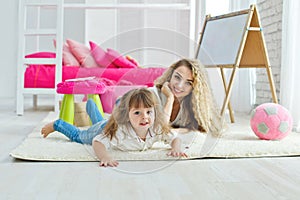 Happy loving family. Mother and daughter in the children`s room. Cute little girl is playing with a woman.