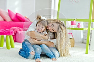 Happy loving family. Mother and daughter in the children`s room. Cute little girl is playing with a woman.