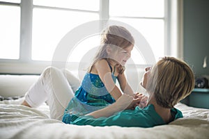 Happy loving family. Mother and her daughter child girl playing and hugging.on bed