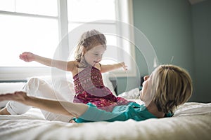 Happy loving family. Mother and her daughter child girl playing and hugging.on bed