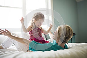 Happy loving family. Mother and her daughter child girl playing and hugging.on bed