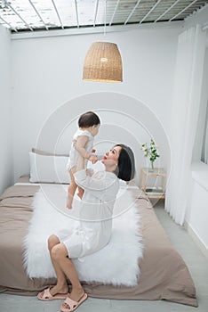 Happy loving family. mother playing with her baby in the bedroom