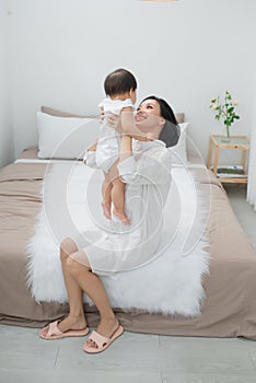 Happy loving family. mother playing with her baby in the bedroom