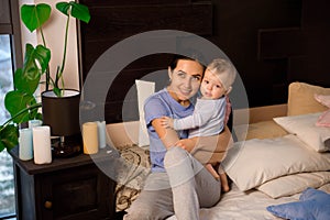 Happy loving family. Mother playing with her baby in the bedroom.