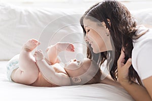 Happy loving family. mother playing with her baby in the bedroom.